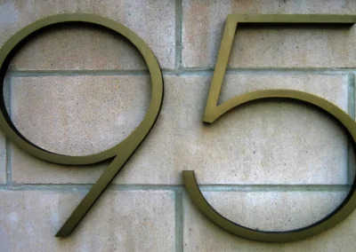 Large metal numerals _95_ mounted on a textured stone wall